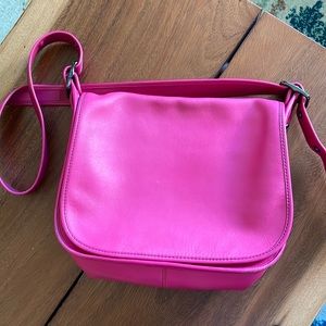 A fuchsia Coach crossbody bag.
